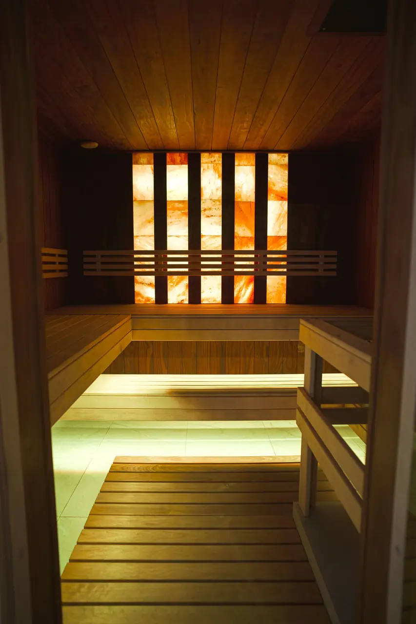 Modern sauna interior with warm wooden panels and salt wall