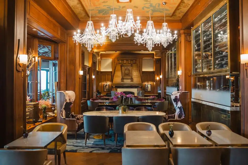 Luxurious dining area with grand chandeliers and plush seating at Pineforgecreative