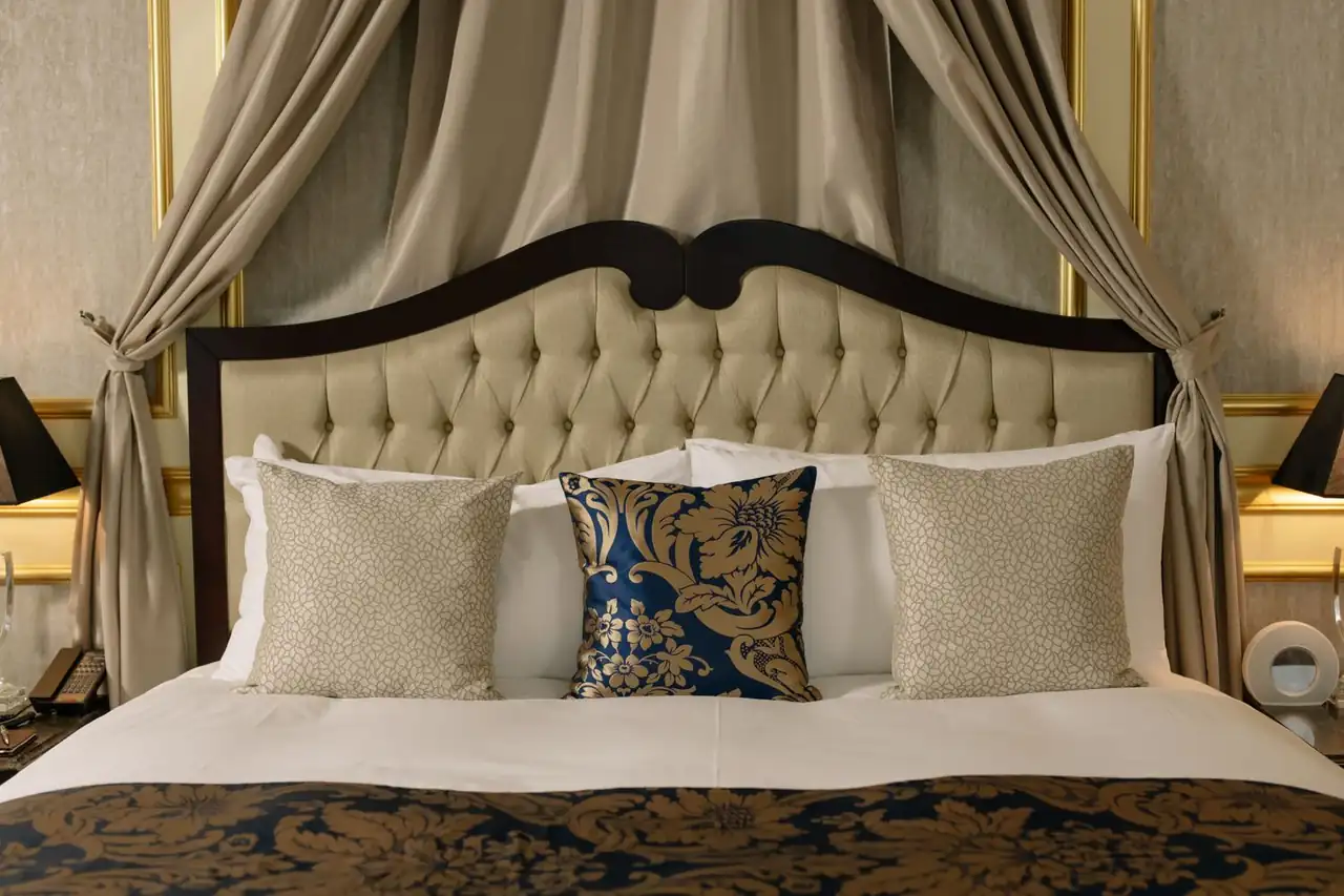 Plush headboard and decorative pillows in a luxury suite